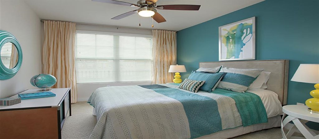 a bedroom with a bed and a ceiling fan