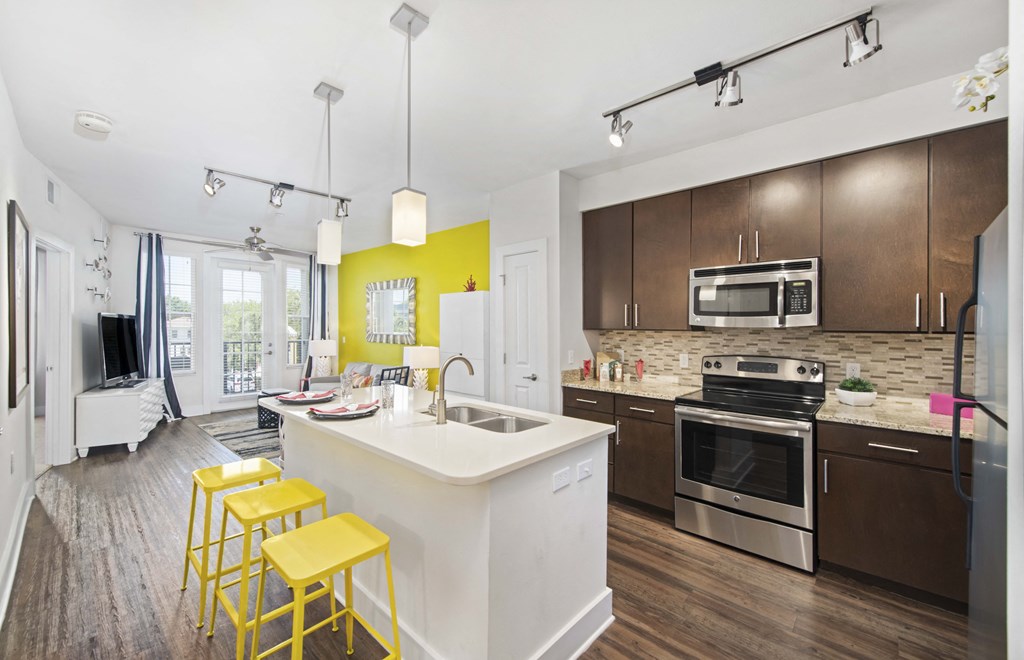 a kitchen with a white island and yellow bar stools