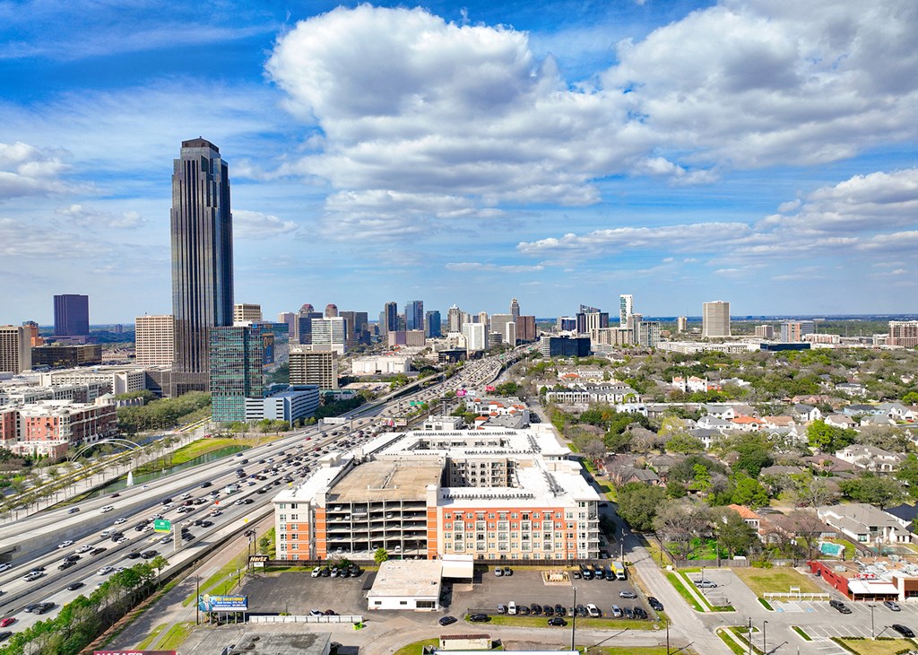 an aerial view of the city with highways and a tall building