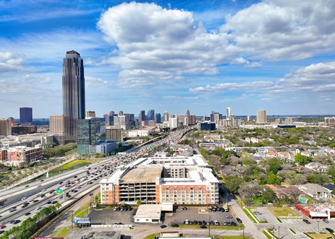 an aerial view of the city with highways and a tall building