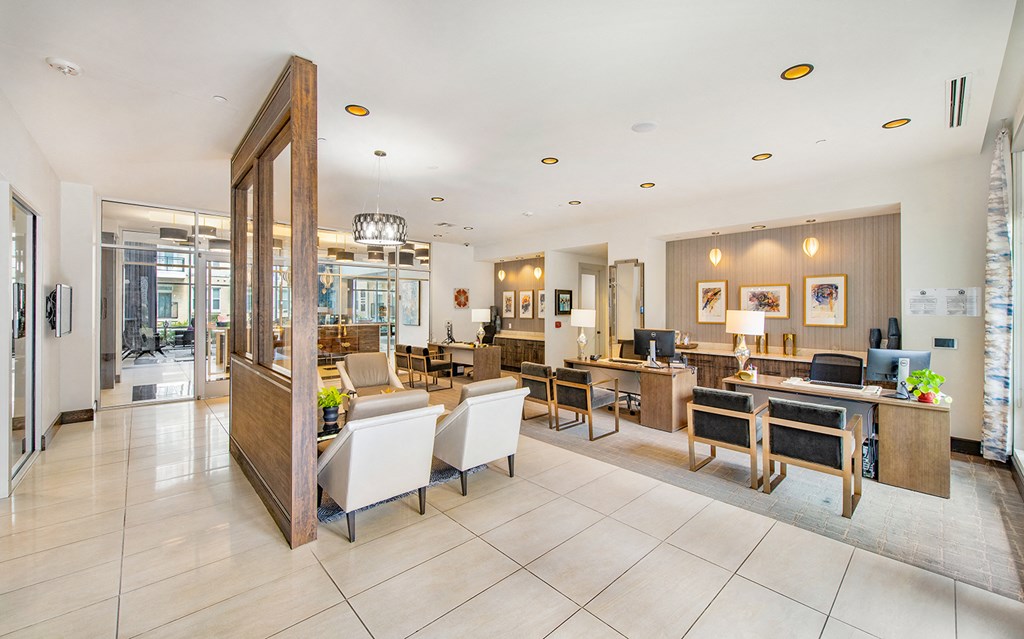 the lobby of a hotel with tables and chairs