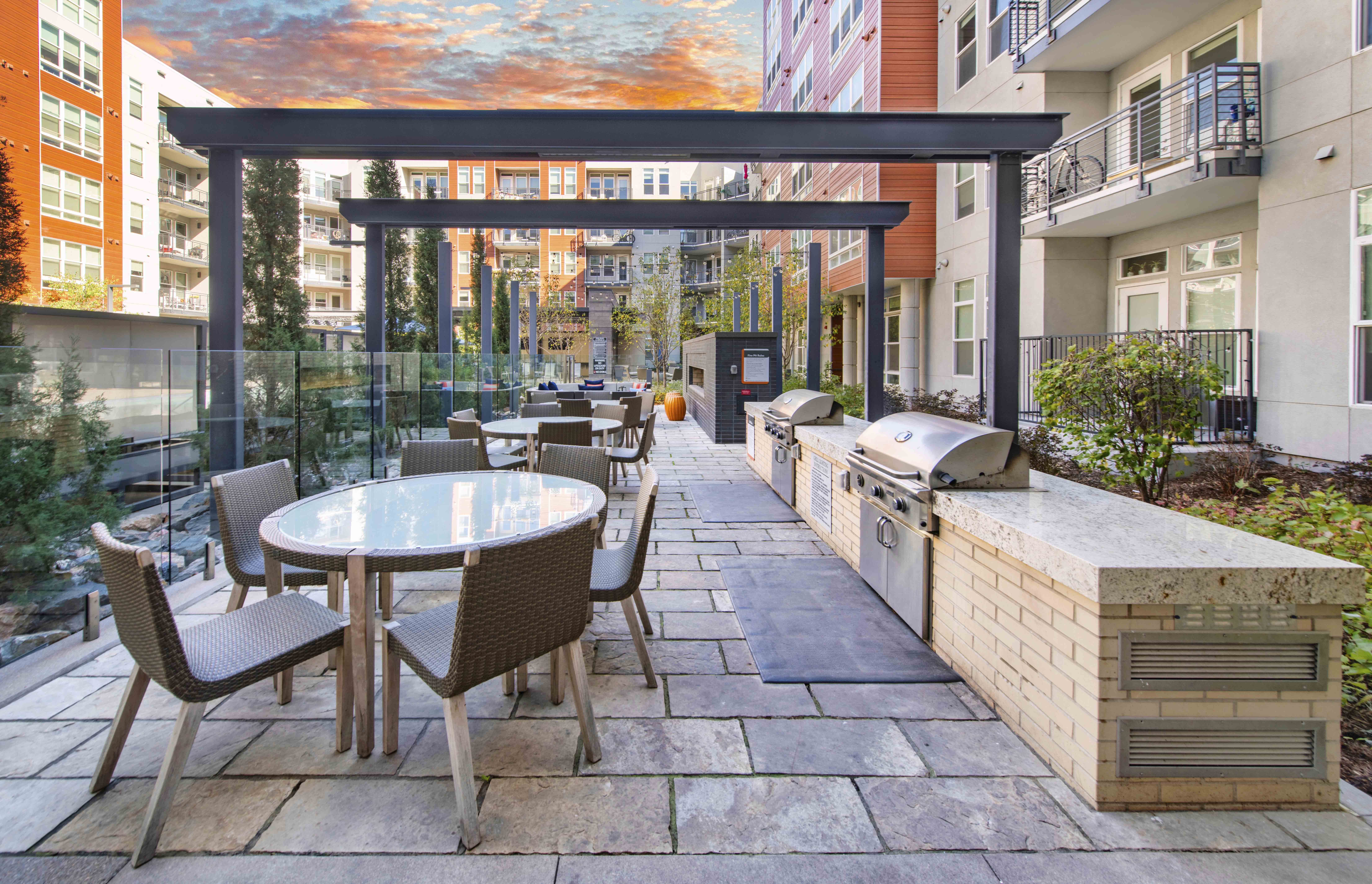 a patio with a grill and a table and chairs