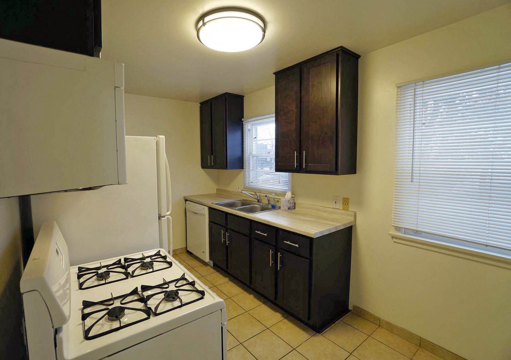 A kitchen with a white stove and black cabinets.
