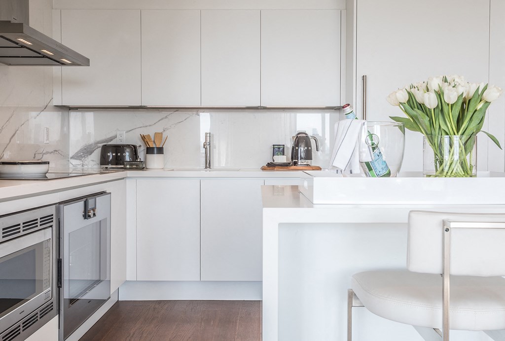 a white kitchen with white cabinets and a white counter