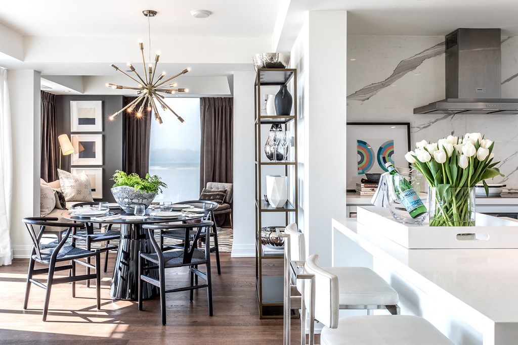 a dining room with a dining table and chairs and a kitchen with a large window