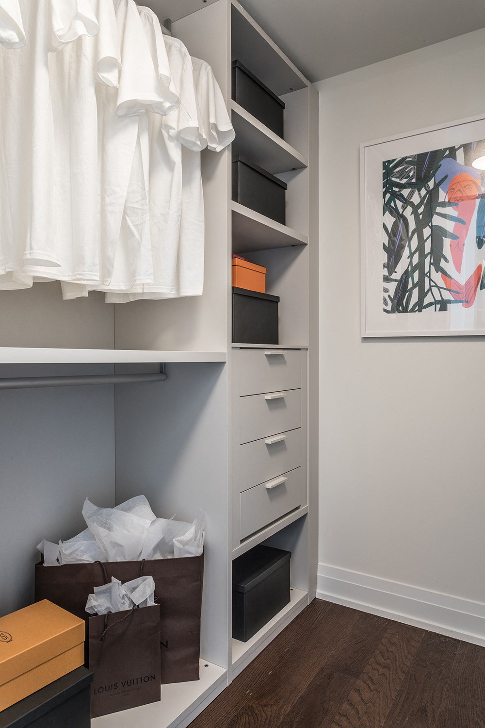a walk in closet with a dresser and a closet organizer
