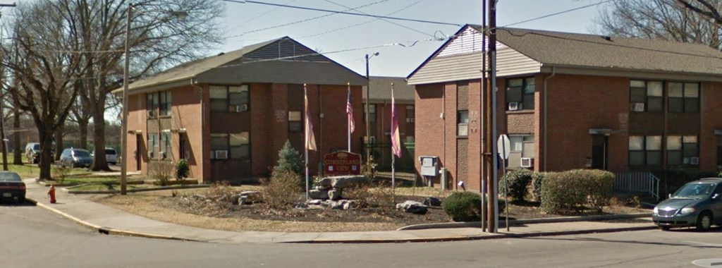 a row of brick apartment buildings on the corner of a street