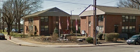 a row of brick apartment buildings on the corner of a street