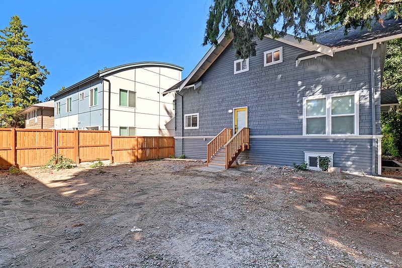 a blue house with a yard and a wooden fence