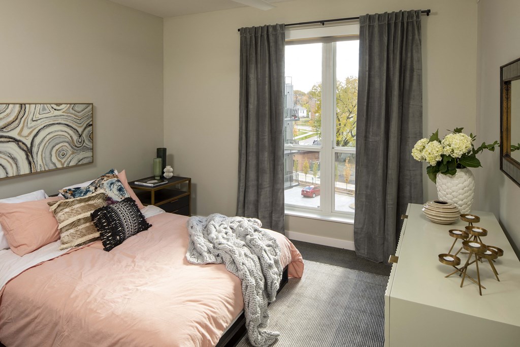a bedroom with a bed and a large window