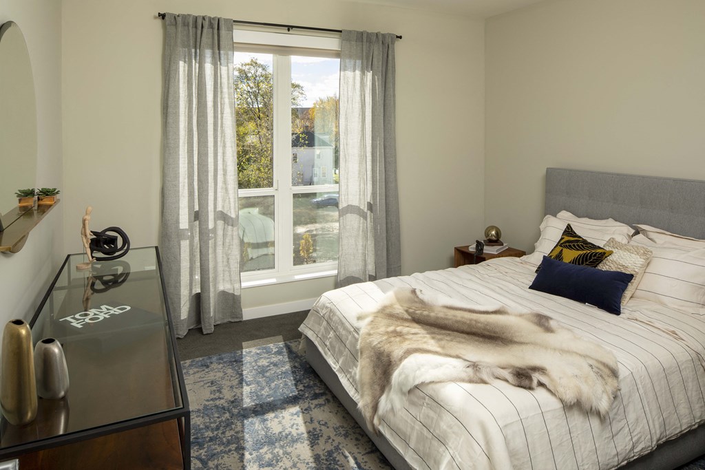 a bedroom with a bed and a large window