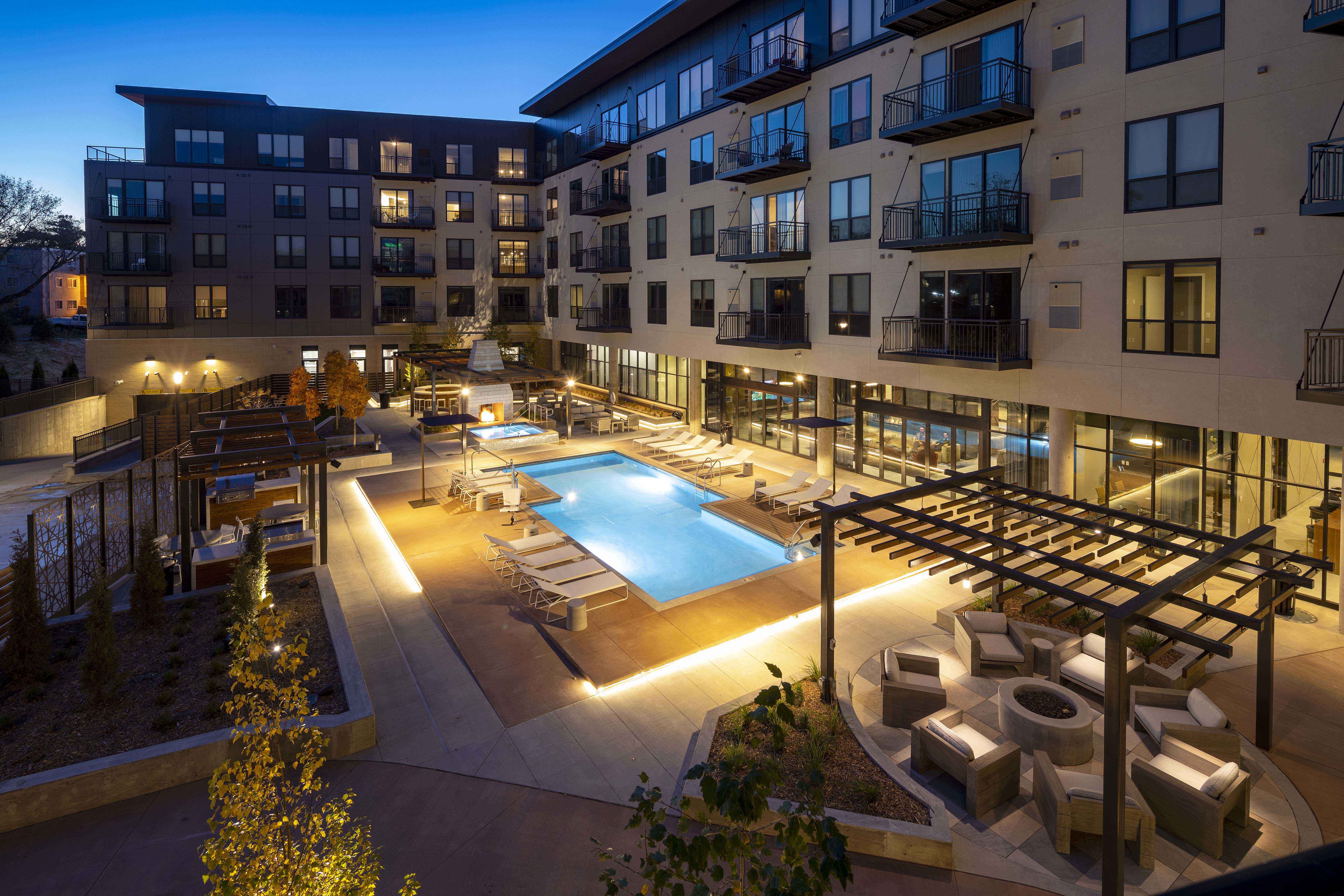 an apartment complex with a swimming pool at night