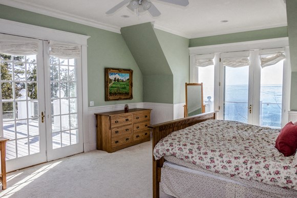 a bedroom with a bed and a view of the ocean