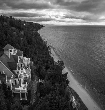 an aerial view of a house next to the ocean