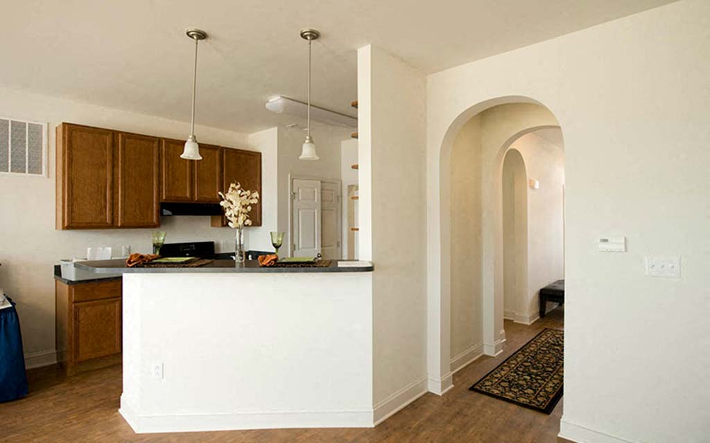 an open kitchen and living room with an arched doorway
