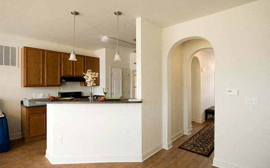 an open kitchen and living room with an archway