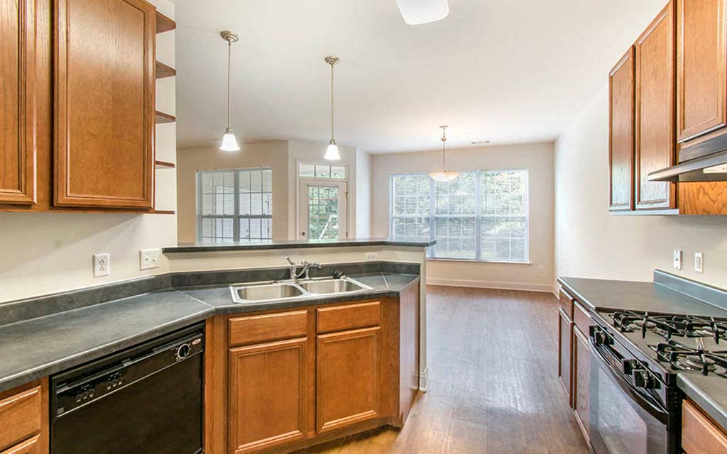 an empty kitchen with wooden cabinets and a sink