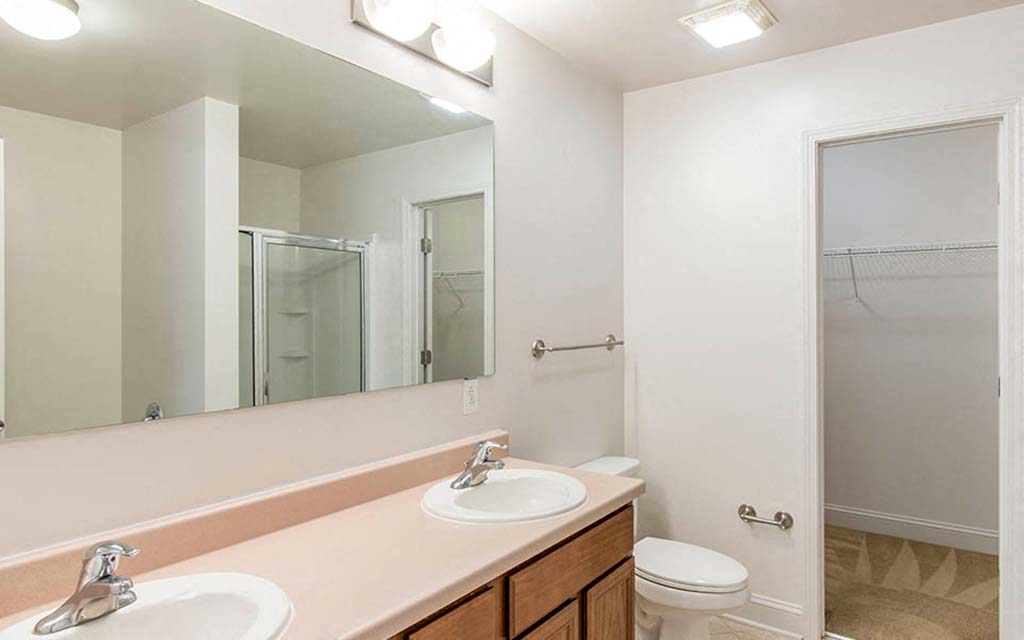 a bathroom with two sinks and a mirror and a toilet