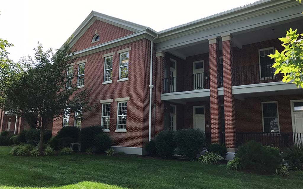 a red brick building with a lawn in front of it