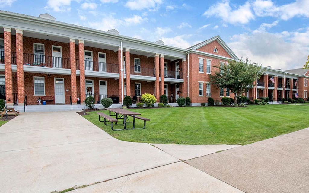 a large brick building with a picnic table in front of it
