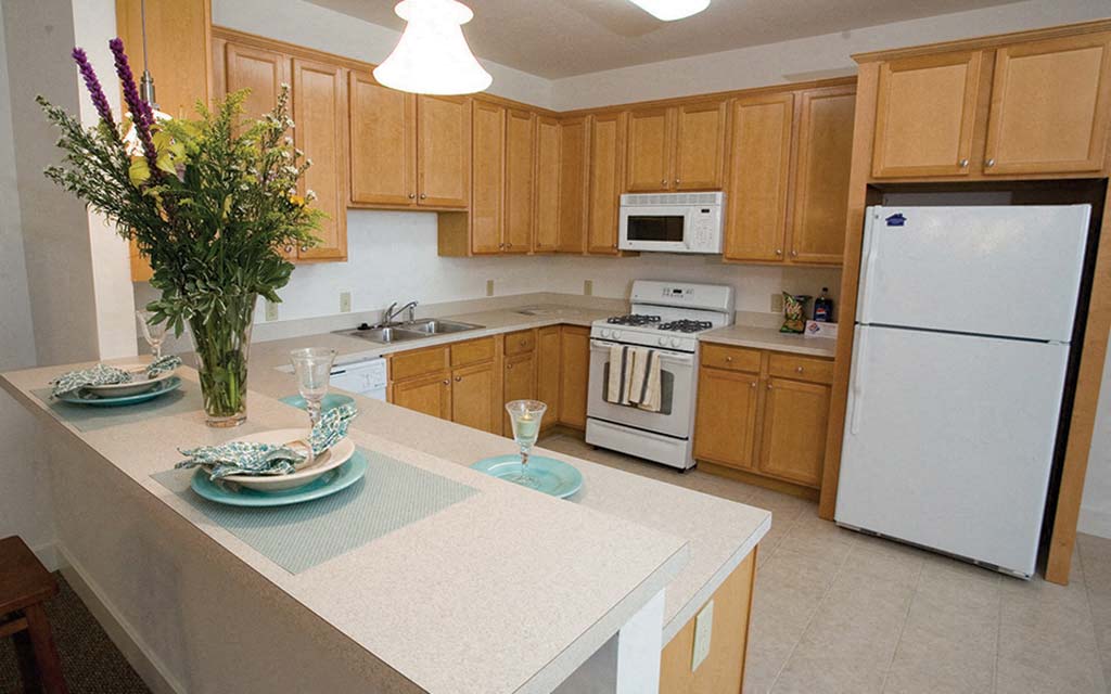 a kitchen with white appliances and wooden cabinets