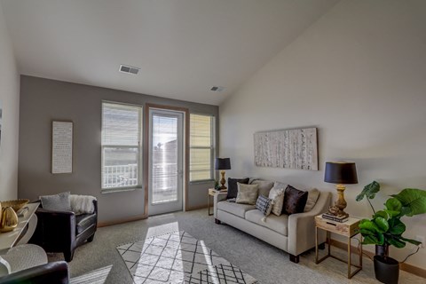 a living room with a white couch and a sliding glass door