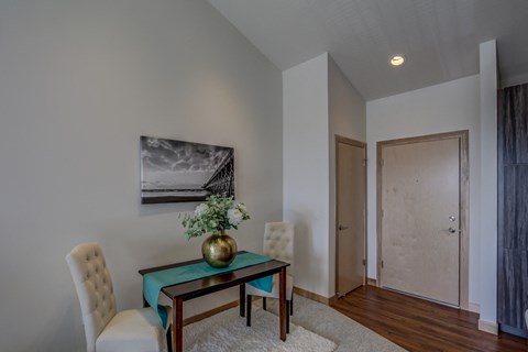 a living room with a table and chairs and a door to a hallway