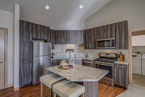 a kitchen with stainless steel appliances and a marble counter top