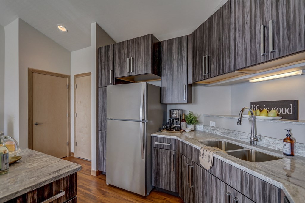 a kitchen with wooden cabinets and a stainless steel refrigerator