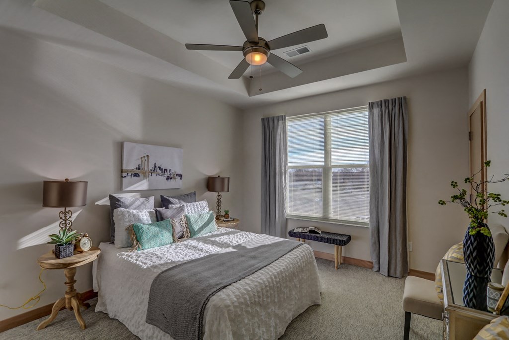 bedroom with ceiling fan and large window at the preserve at greatstone