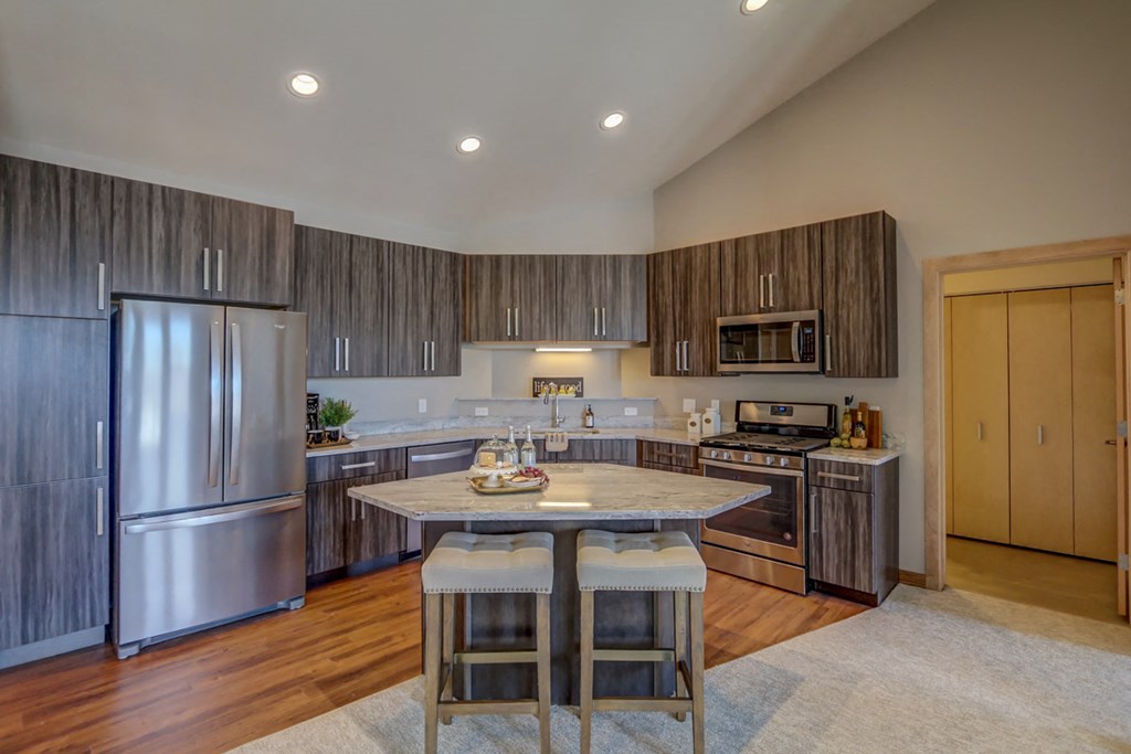 a kitchen with a center island and stainless steel appliances