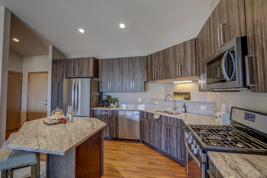 a kitchen with stainless steel appliances and marble counter tops