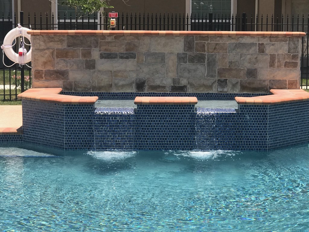 a swimming pool with three lounge chairs in the water