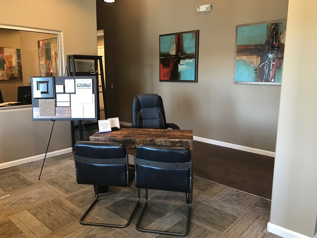 a conference room with a table and chairs and paintings on the wall