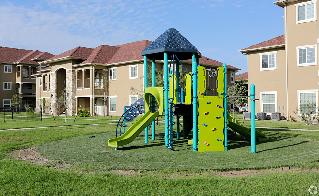 a playground with an apartment building in the background
