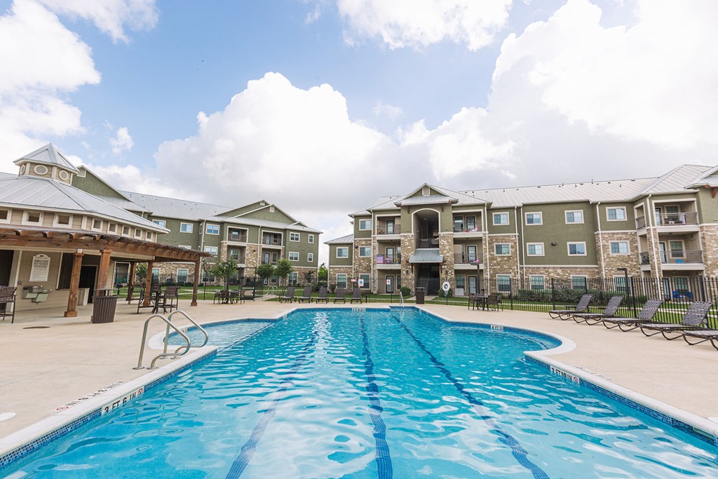 a swimming pool with an apartment building in the background
