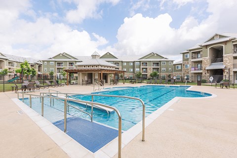 a swimming pool with apartments in the background