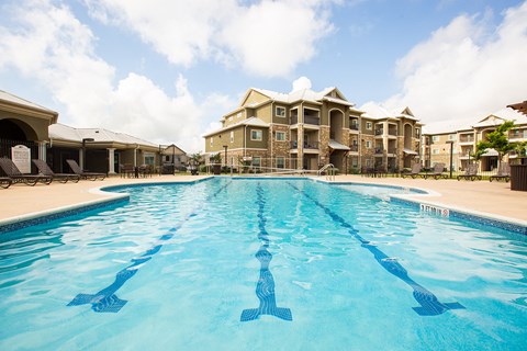 a large swimming pool with apartments in the background