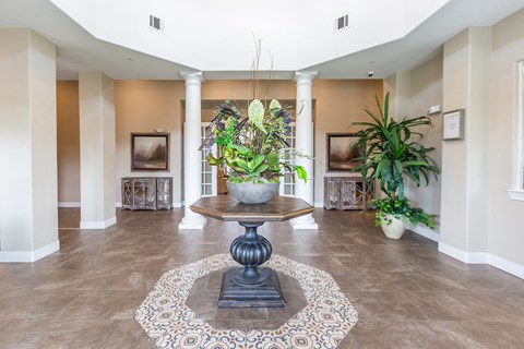a lobby with a table and a potted plant