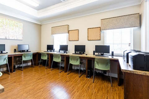 a computer room with desks and chairs and monitors