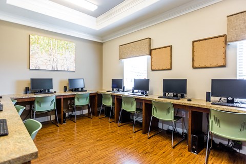 a computer room with desks and chairs and monitors