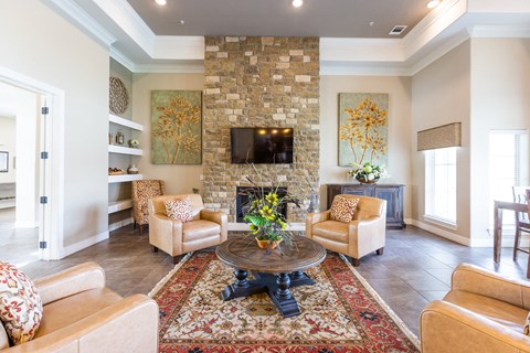 a living room with a stone fireplace and a coffee table