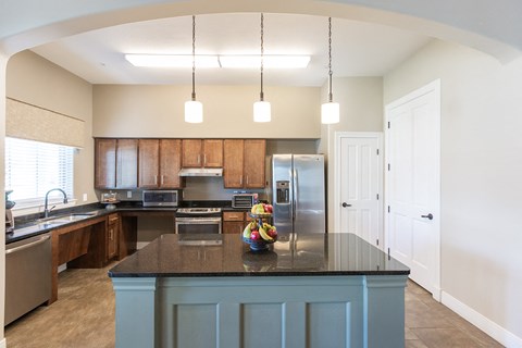 a kitchen with a blue island and a stainless steel refrigerator
