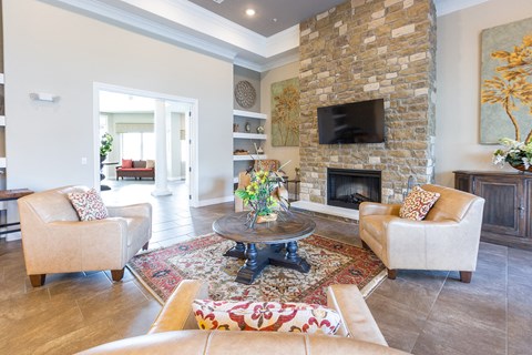 a living room with a stone fireplace and two chairs