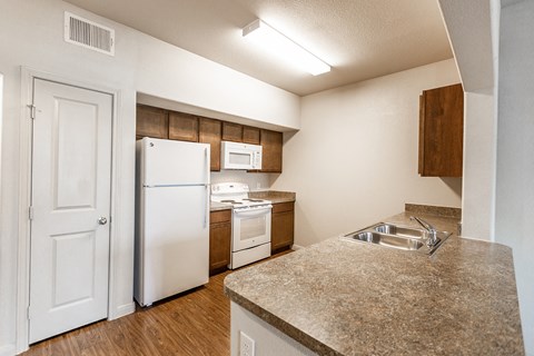 a kitchen with white appliances and a sink and a refrigerator