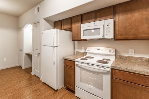a kitchen with white appliances and wooden cabinets and a white refrigerator