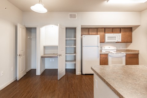 an empty kitchen with white appliances and a white refrigerator