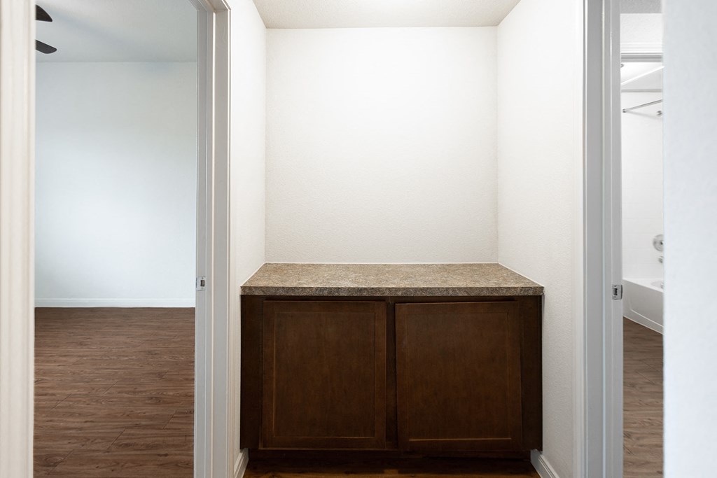 an empty room with wooden cabinets and a white wall