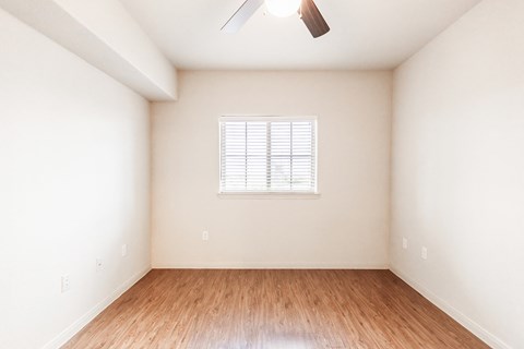 an empty room with wood floors and a window