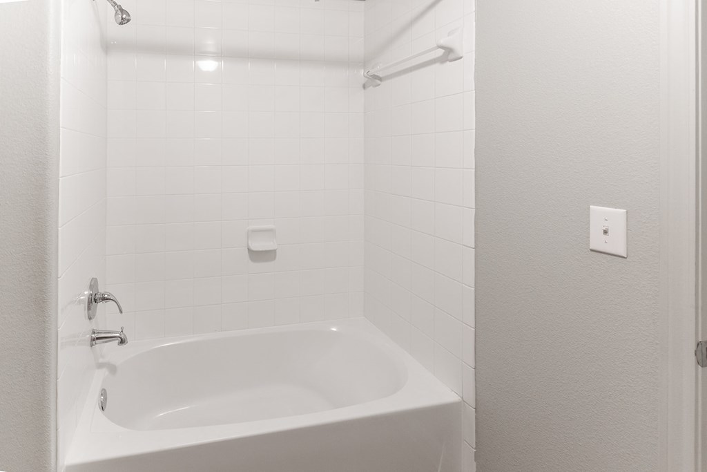 a white bathroom with a tub and a shower
